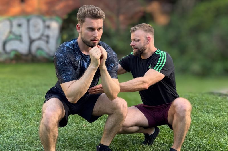 Robert Lang korrigiert die Kniebeuge eines Klienten